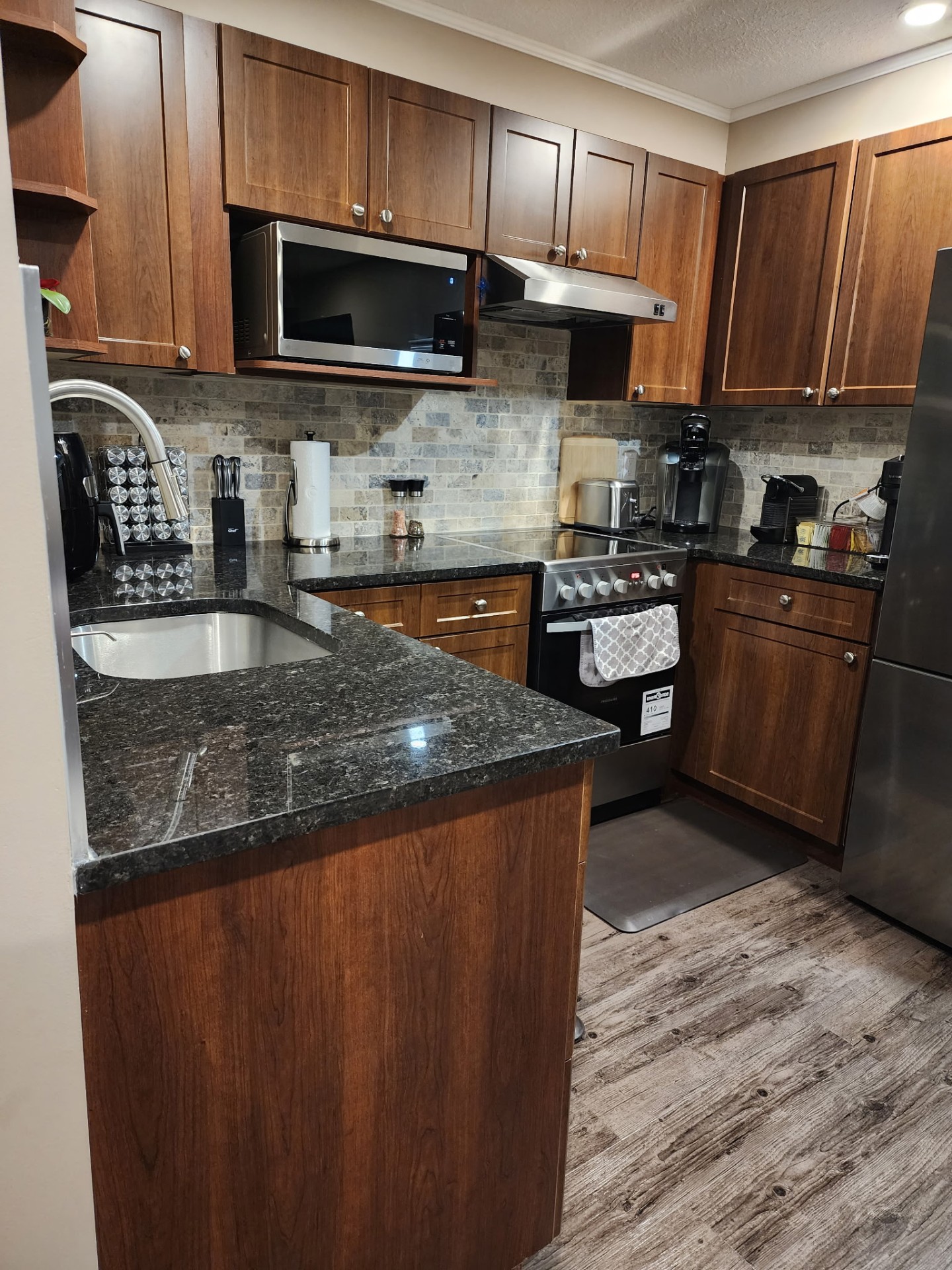 Modern kitchen with granite counters, freshly cleaned