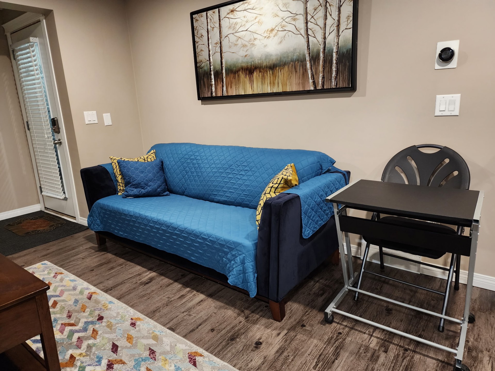 Tidy living area with sofa and workspace